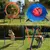 Agility-Set mit Sprungring, Tunnel, Hürden und Slalomstangen für Hunde im Garten. Hund demonstriert Nutzung der Hindernisse.