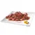 Chunks of meat in gravy with visible pieces of orange and green vegetables on a white square plate, small garnish at the side. No brand or text visible.