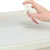 Hand sprays liquid from a white spray bottle onto an absorbent pad.