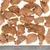 Morceaux de friandises brunes déshydratées pour animaux, disposés sur fond blanc avec une règle en centimètres indiquant la taille des morceaux, environ 3 à 6 cm chacun.