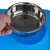 Hand holding a stainless steel bowl over a blue non-slip mat with embossed paw patterns.