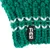 Tiaki logo on green knitted material with white accents.