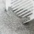 Close-up of grey cat litter being sifted with a white scoop.