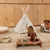 Wooden feeding bowl with two stainless steel dishes, dog eating. In the background a white tipi and a striped dog bed with a sitting dog.