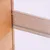 Dettaglio di una striscia di metallo perforata fissata tra due pannelli di legno.