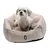 Tiaki dog bed in beige with soft plush padding, small dog sitting inside.