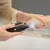 Hand hält elektrischen Krallenschleifer mit LED-Licht, während Hundepfote bearbeitet wird.