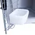 White plastic drinking bowl attached to a metal grid of a transport box.