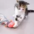 Gatito juega con un juguete de pez de tela rojo atado a una cuerda.
