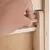 Hand showing how a wooden peg is inserted into an opening in a wooden frame.