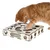 Chat roux utilisant un jeu d’intelligence en bois avec plusieurs ouvertures de formes variées sur le dessus et les côtés.