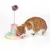 Katzenspielzeug mit bunter Plüschbasis und Federstab, an dessen Spitze ein mehrfarbiger Pompon befestigt ist. Eine rot-weisse Katze interagiert mit dem Spielzeug.