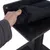 Main soulevant un coussin en tissu noir fixé par scratch sur une plateforme en bois foncé d’un arbre à chat, montrant la fixation amovible du coussin.