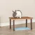 Plataforma de madera con patas de madera natural, adecuada como superficie elevada para pequeños animales. Un conejo está sentado en la plataforma.