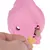 Main insérant une friandise en forme d’os dans un jouet distributeur rose pour animaux, ouverture visible avec une autre friandise à l’intérieur. Jouet en plastique.