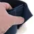 Gros plan sur une main ouvrant une fermeture velcro noire avec intérieur en tissu et doublure imitation fourrure blanche, montrant le système d’attache du produit.
