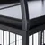 Detailní záběr černé kovové klece s mřížovými stěnami a stabilní horní policí z kovu.