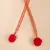 Net toy with red and gold accents, two red plush balls at the ends.