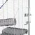 Cage à barreaux blancs avec biberon en plastique transparent fixé, tunnel suspendu en plastique gris et plateforme intérieure grise visibles.