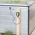 Elektronisches Schneckenabwehrgerät Snail Stop, montiert an einem Holzpfosten neben einem Gewächshaus. Kabel und Sensor sichtbar.
