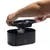 Fontaine à eau noire en plastique beeztees, couvercle amovible tenu par une main, réservoir et filtre visibles à l’intérieur.