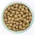Cuenco con piezas redondas de pienso seco marrón. Primer plano del alimento sin información visible de marca o producto.
