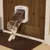 Cat using a white PetSafe pet door installed in a wooden door, demonstrating how the product allows pets to move through doors independently.