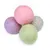 Quatre balles en feutre aux couleurs pastel : rose, violet, vert et gris.
