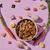 Bowl of cubed pet food surrounded by raw chicken pieces, carrots, hard-boiled eggs, carrot slices and seeds, showing visible ingredients used in the product.