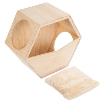 Casa de madera hexagonal con dos aberturas redondas y cojín beige suave. Adecuada como refugio o lugar para dormir.
