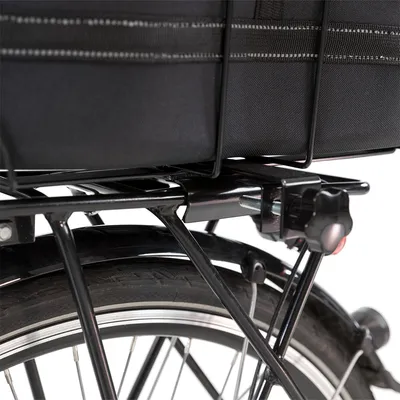 Nahaufnahme eines Fahrradträgers mit schwarzer Tasche, befestigt über Metallrahmen und Schraubverschluss.