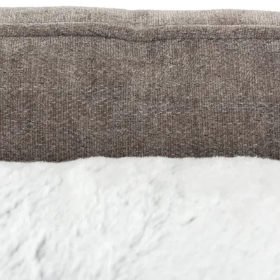Nahaufnahme eines braunen Stoffmaterials und einer weissen, weichen Plüschoberfläche. Materialdetails für ein Haustierbett sichtbar.