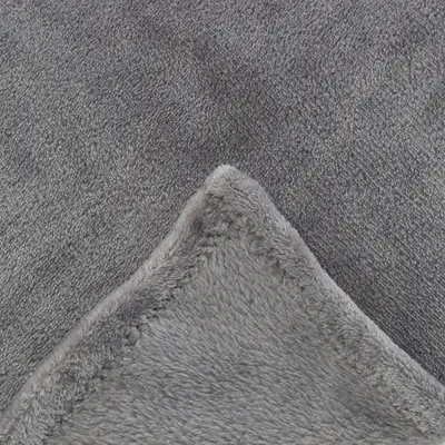 Close-up of a grey, soft fabric blanket with visible seams and fluffy texture.