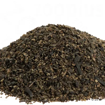 Nahaufnahme von braunen, grob zerkleinerten Pellets oder Futterstücken. Keine weiteren Informationen sichtbar.
