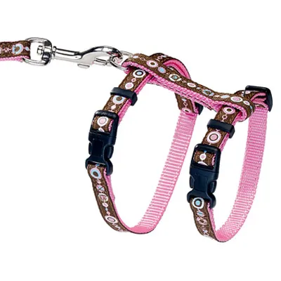Pettorina regolabile con design marrone e rosa, motivi decorativi e chiusure a scatto. Gancio in metallo per il guinzaglio visibile.