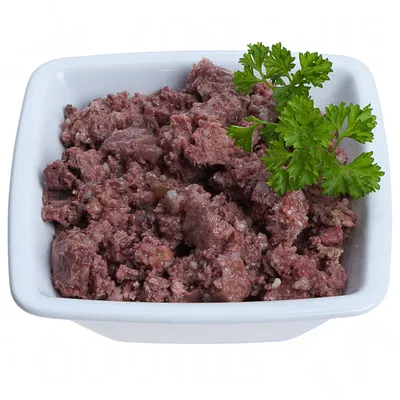 Bowl with red, minced meat and parsley sprig as garnish.