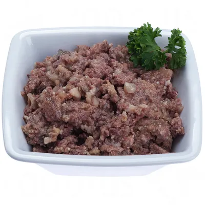 Kulho, jossa ruskeaa, rakeista märkäruokaa ja persiljan oksa koristeena. Tuotemerkki tai tarkempi sisältö ei näkyvissä.