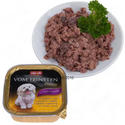 Animonda Vom Feinsten Classic hondenvoer, met kalkoen en lam. Verpakking en inhoud op een bord zichtbaar, garnering met peterselie. Tekst: mit Pute + Lamm, met kalkoen + lam.
