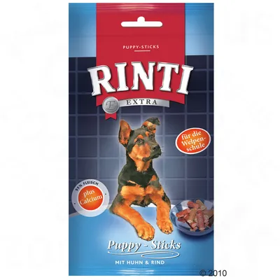 Rinti Extra Puppy-Sticks mit Huhn & Rind, 95% Fleisch, plus Calcium, für die Welpenschule. Afbeelding van een puppy en een bakje met sticks op de verpakking.