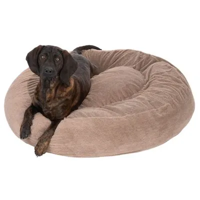 Bruine hond ligt op een groot, rond hondenbed van beige stof. Geen merknaam of extra tekst zichtbaar.