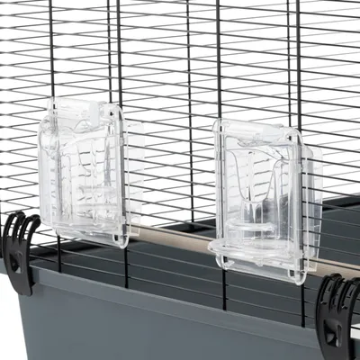 Close-up of two transparent plastic feeders attached to the side of a wire cage, showing how they are fixed in place for easy access inside the enclosure.