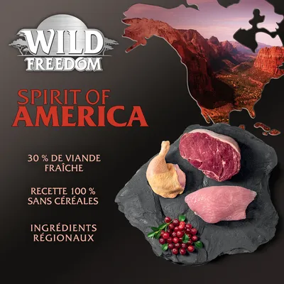Wild Freedom Spirit of America, 30 % de viande fraîche, recette 100 % sans céréales, ingrédients régionaux. Viande crue et airelles visibles sur une ardoise.