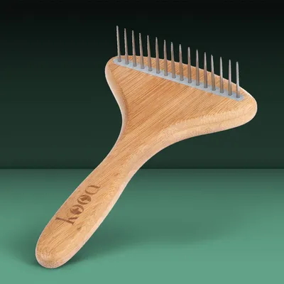 Pettine kooa con manico in legno e denti metallici, marchio visibile sull'impugnatura.