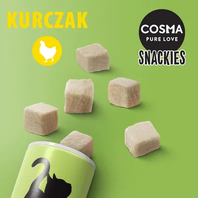 COSMA PURE LOVE SNACKIES, kurczak. Sześć jasnych kostek przysmaku wysypanych z zielonego opakowania z sylwetką kota na zielonym tle.