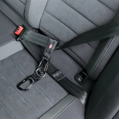 Seat belt adapter for car seat with ISOFIX system, visible black carabiner and adjustable straps.