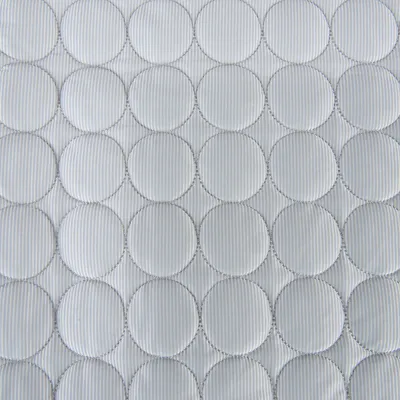 Vaaleanharmaa kangas, jossa pyöreitä tikattuja kuvioita ja ohuita pystyraitoja. Materiaali: kangas. Näkyvissä ei ole tuotemerkkiä tai tekstiä.