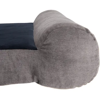 Detailweergave van een grijs en donkerblauw huisdierenbed met gewatteerde stoffen rand.