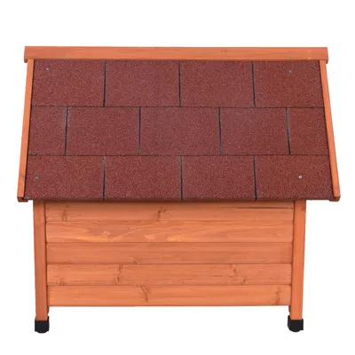 Houten hondenhok met rood shingles dak en verhoogde zwarte poten, geschikt voor buitengebruik.