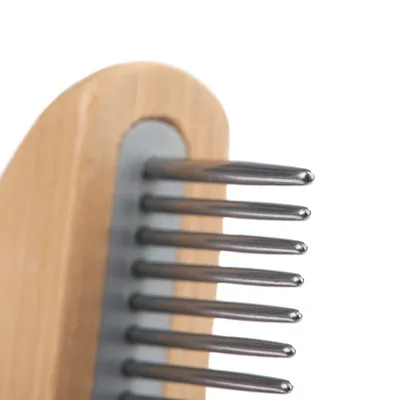 Nahaufnahme eines Kamms mit Holzgriff und Metallzinken, geeignet für die Fellpflege.