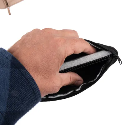 Ruka otvára čiernu tašku na zips, ktorá obsahuje sivú filtračnú vložku.